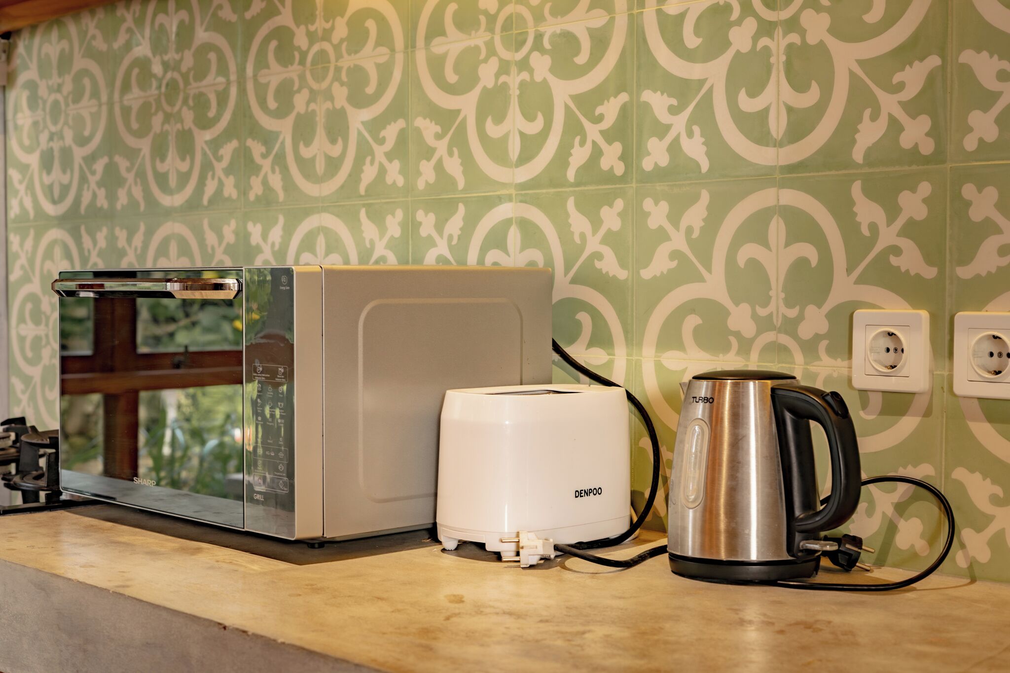 A kitchen with a toaster, a kettle, and a window.