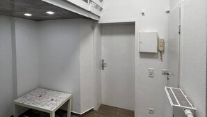 Una stanza compatta con un letto a castello, un tavolino e un tappeto decorato.