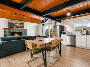 A modern kitchen with a built-in stove, stainless steel appliances, and a window overlooking a snowy landscape.