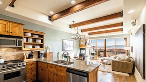 A kitchen with wooden cabinets, a dishwasher, a stove, and a large island with a sink. - Redstone Condo in Great Location, Hot Tub & Year-Round Recreation! Park City Newark 38 (Park City)