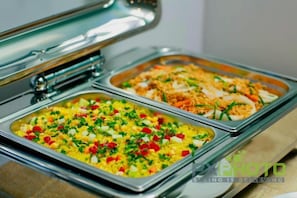 A buffet with two trays of food, one with rice and vegetables, and the other with a rice dish topped with shredded cheese. - Sun Diamond Hotel (Bai Chay)