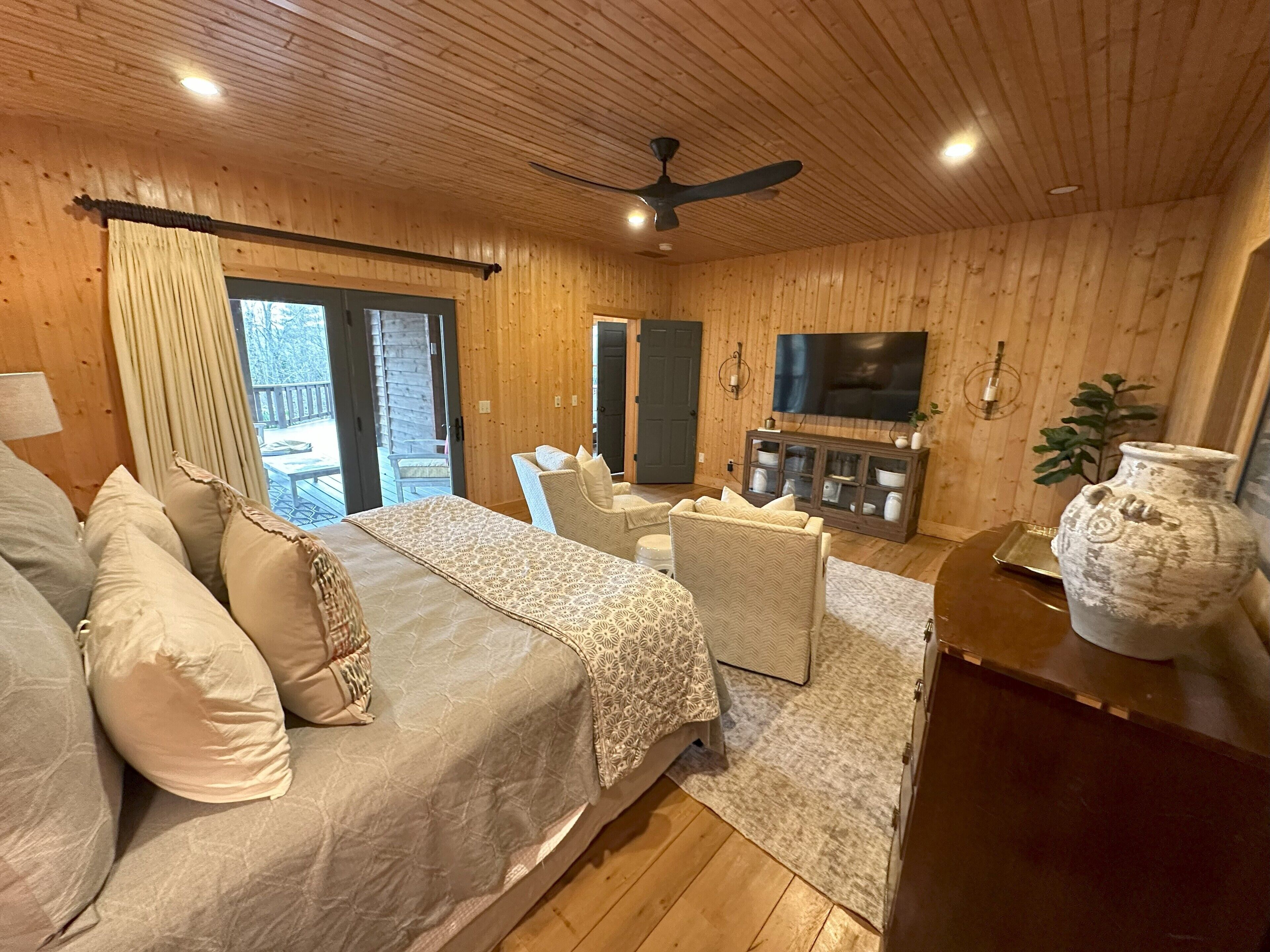 Una habitación acogedora con cama, zona de estar, televisor y armario.