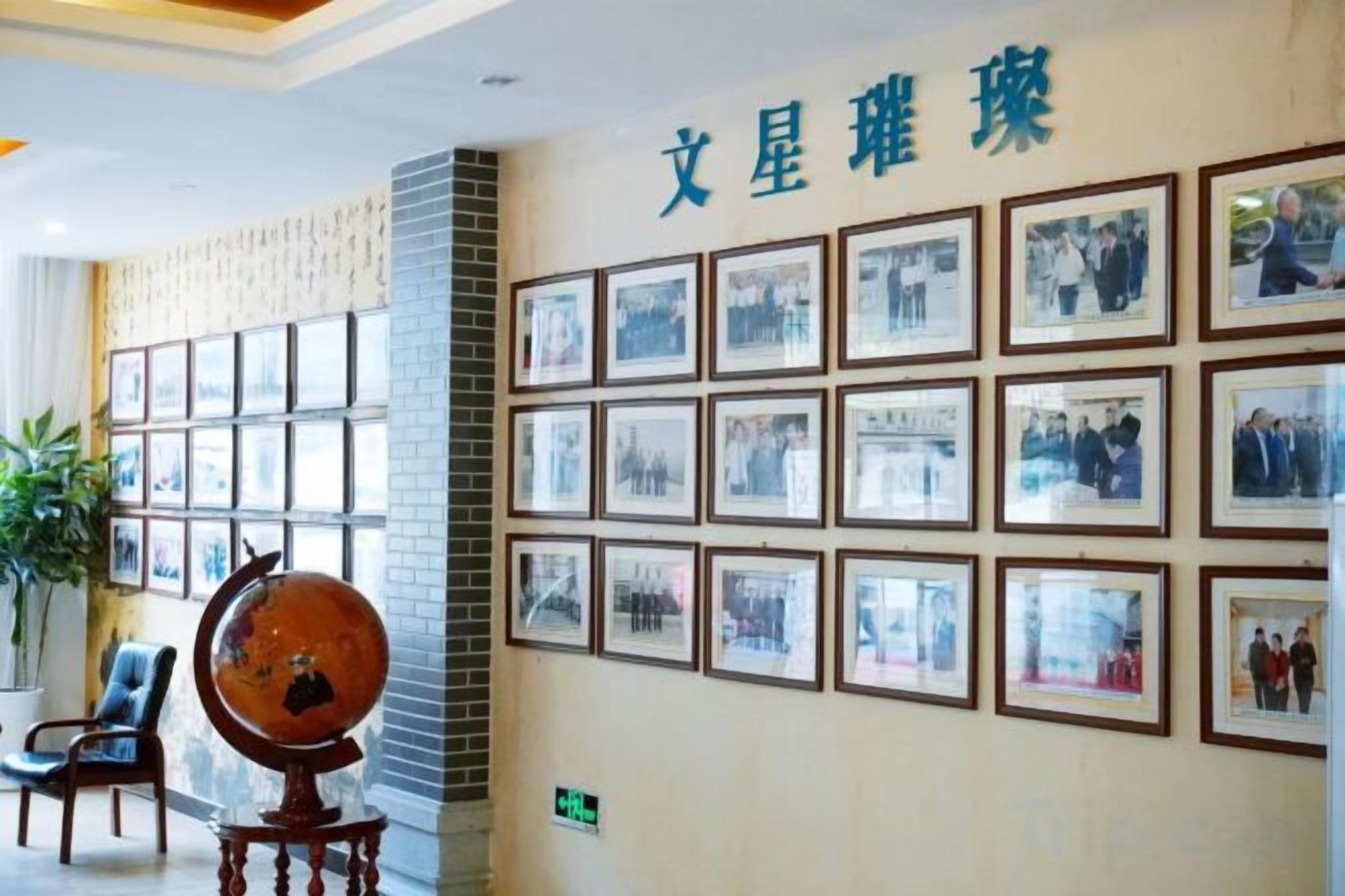 A wall with framed photographs and a globe on a stand.