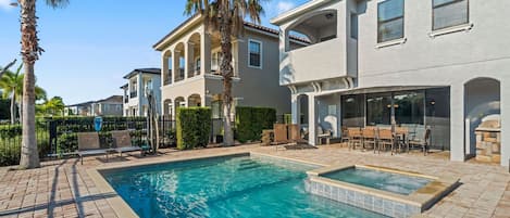 A residential property with a swimming pool, outdoor seating area, and a covered patio.