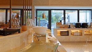 A modern hotel lobby with a reception desk, glassware, and a view of the outside. - Ji Hotel Xiamen Sm Plaza Chenggong Avenue (Chuzhou)