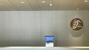 A hotel reception desk with a digital kiosk and a wall-mounted sign displaying the hotel name. - Ji Hotel Xiamen Sm Plaza Chenggong Avenue (Chuzhou)