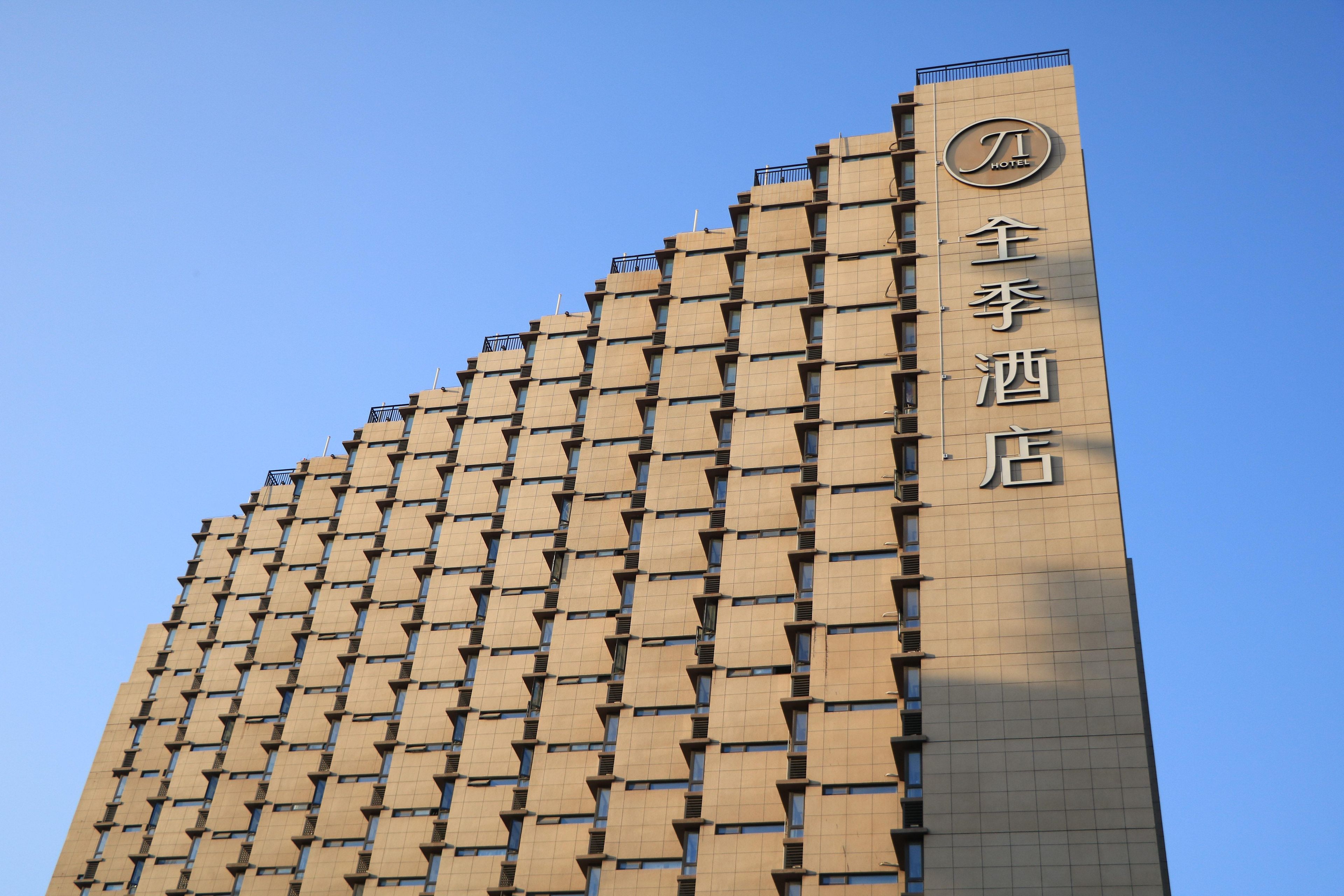 A hotel building with a distinctive geometric facade and a sign indicating it is a hotel.