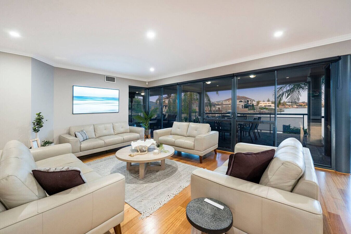 A spacious living room with a large window, a coffee table, and two sofas.