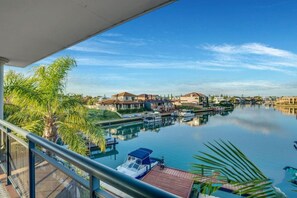 A marina with boats, a clear sky, and residential buildings in the background.