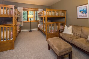 A room with bunk beds, a sofa, and a framed picture on the wall. - Big Sky Condo! Private Hot Tub & Sauna! Mountain Views! (Big Sky)