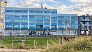 Ein mehrstöckiges Gebäude mit moderner Architektur, das ein flaches Dach und große Fenster aufweist.