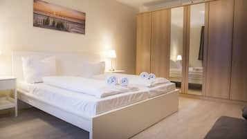 Ein Hotelzimmer mit einem großen Bett, einem Nachttisch, einer Lampe, einem Kleiderschrank und einem Gemälde an der Wand.