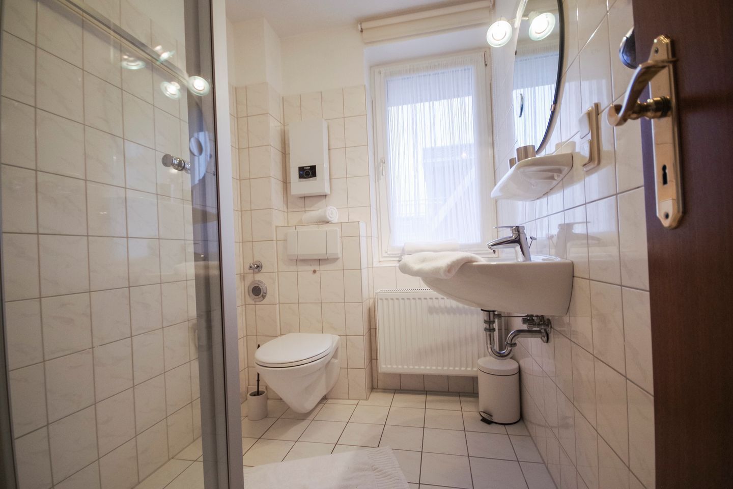 Ein Badezimmer mit Toilette, Waschbecken, Spiegel und Fenster.