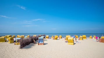 En strand med gule strandhytter og en klar blå himmel.