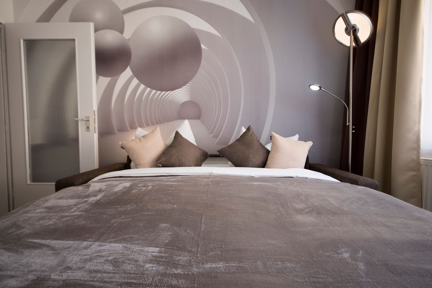 Ein modernes Schlafzimmer mit einem großen Bett, einem Kleiderschrank und einem einzigartigen Wanddesign.