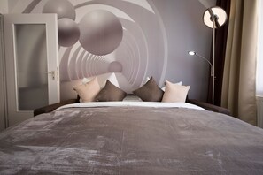 Un dormitorio moderno con una cama grande, un armario y un diseño de pared original.