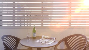 A table with a bottle, glasses, and a magazine. - Punthill Essendon North (Essendon)