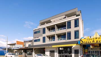 A multi-story building with a ground-level business on the right, featuring a sign for 'Spoton Signs & Printing'.