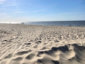 A sandy beach with gentle waves and a clear sky.