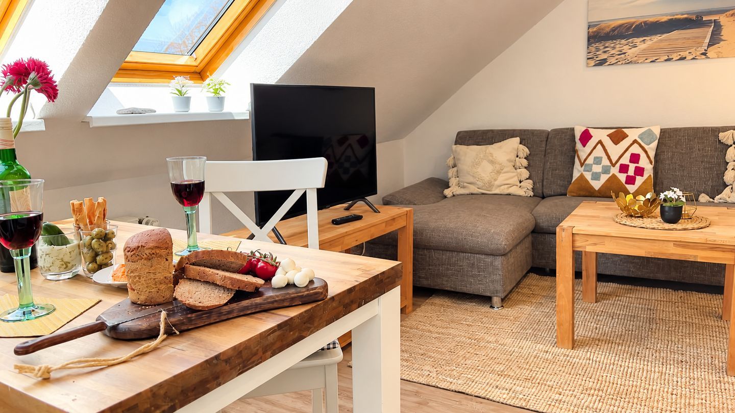 A cozy living space with a dining area, a sofa, and a television.