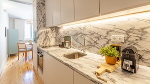 A modern kitchen with a marble countertop, stainless steel sink, and a coffee machine. - D&S -JB Apartments - B (Oporto)