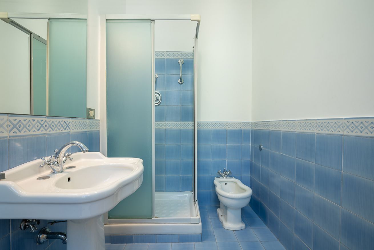 Een badkamer met een douche, wastafel en een toilet met douchefunctie.