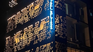 Fachada de hotel con un diseño geométrico y el nombre "HOTEL BLISS" iluminado.