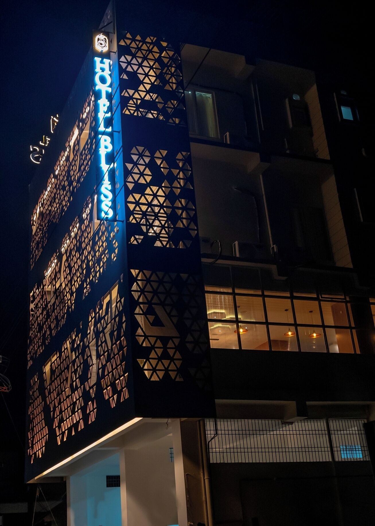 A hotel with a distinctive geometric facade and illuminated signage.