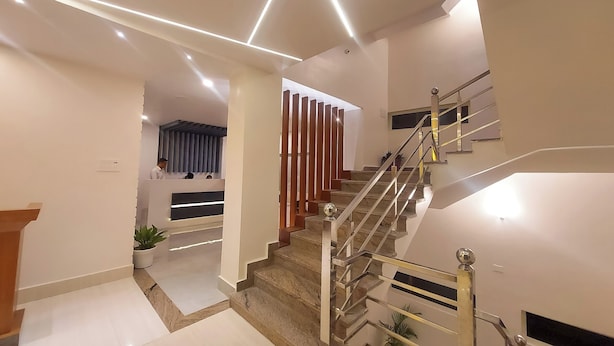 Un interior moderno con una escalera, un mostrador de recepción y una zona de espera.