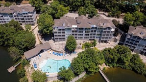Ein mehrstöckiges Hotel mit Schwimmbad, umgeben von Bäumen.