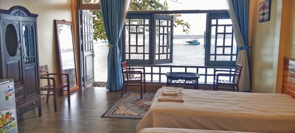 A room with a bed, a desk, and a view of the sea through open windows. - Phu Quoc Harbour View Villa (Phu Quoc)