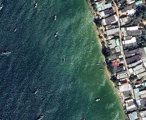 An aerial view of a coastal area with a dense cluster of buildings near the shoreline.