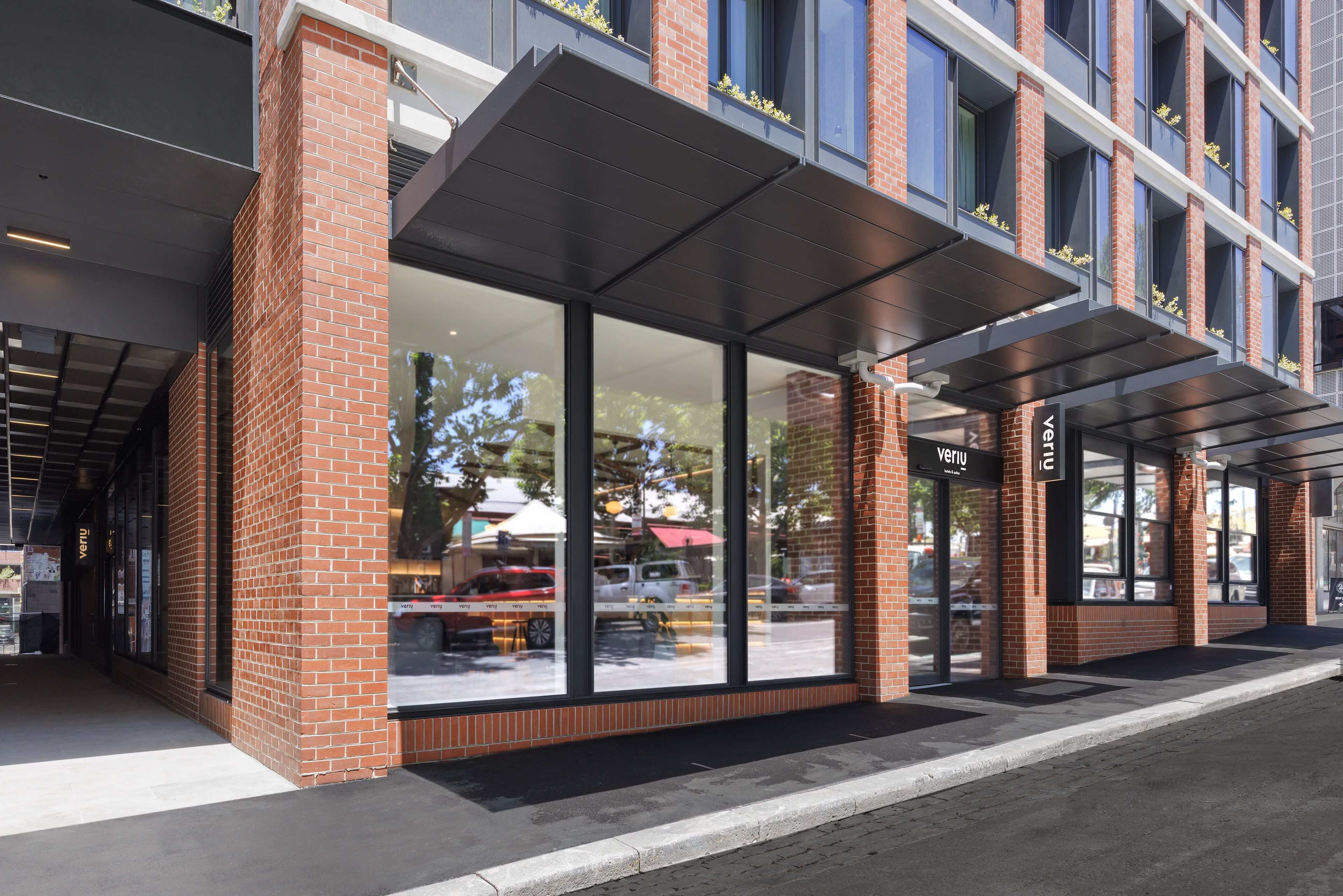 A modern building with large windows and a covered entrance area.
