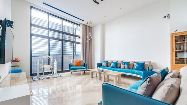 A modern living room with a large window, a sofa set, a coffee table, and a wooden cabinet. - Wenshui (Jiaoxi)