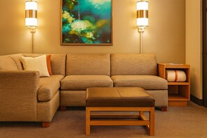 A modern living room with a sectional sofa, a wooden bench, and two wall-mounted lamps. - Better Choice For Your Vacation! Pet Friendly Unit, Near Hermitage Plantation! (Duluth)