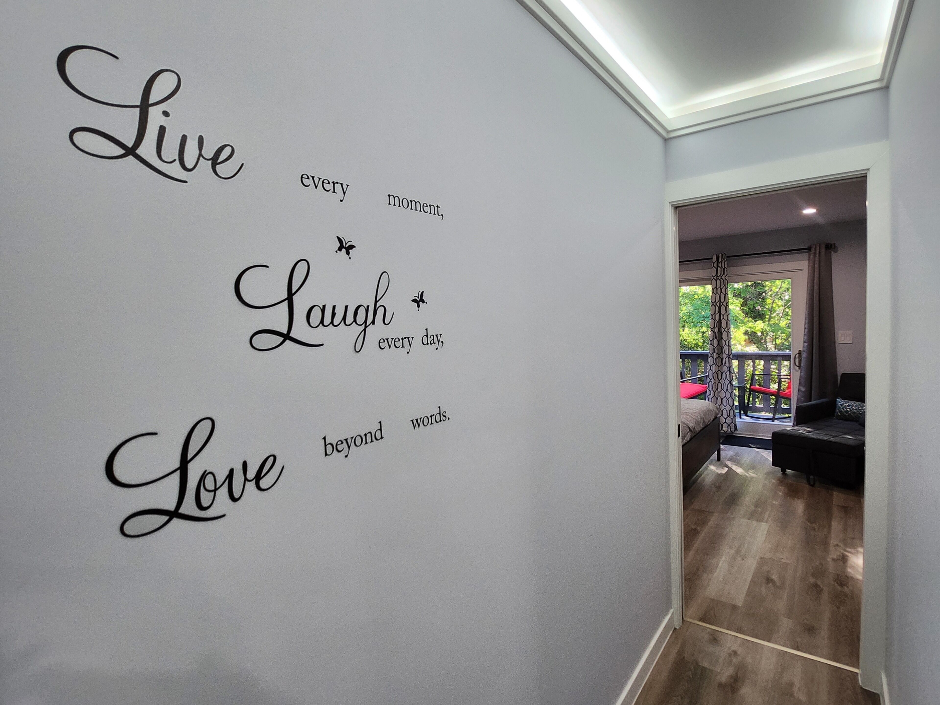 Habitación con un vinilo decorativo inspirador y vistas a un balcón exterior.