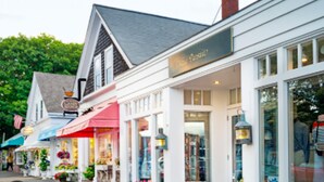 A row of shops with awnings, a sign reading "The Inn," and a bell on the roof.