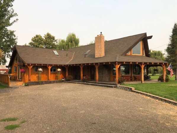 A large, rustic building with a sloped roof and multiple windows.