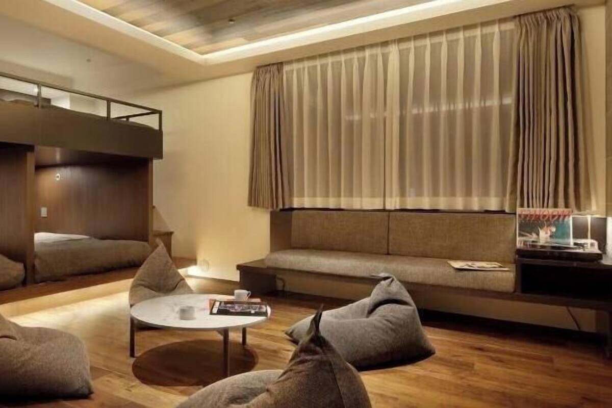 A modern room with bunk beds, a sofa, and bean bags.