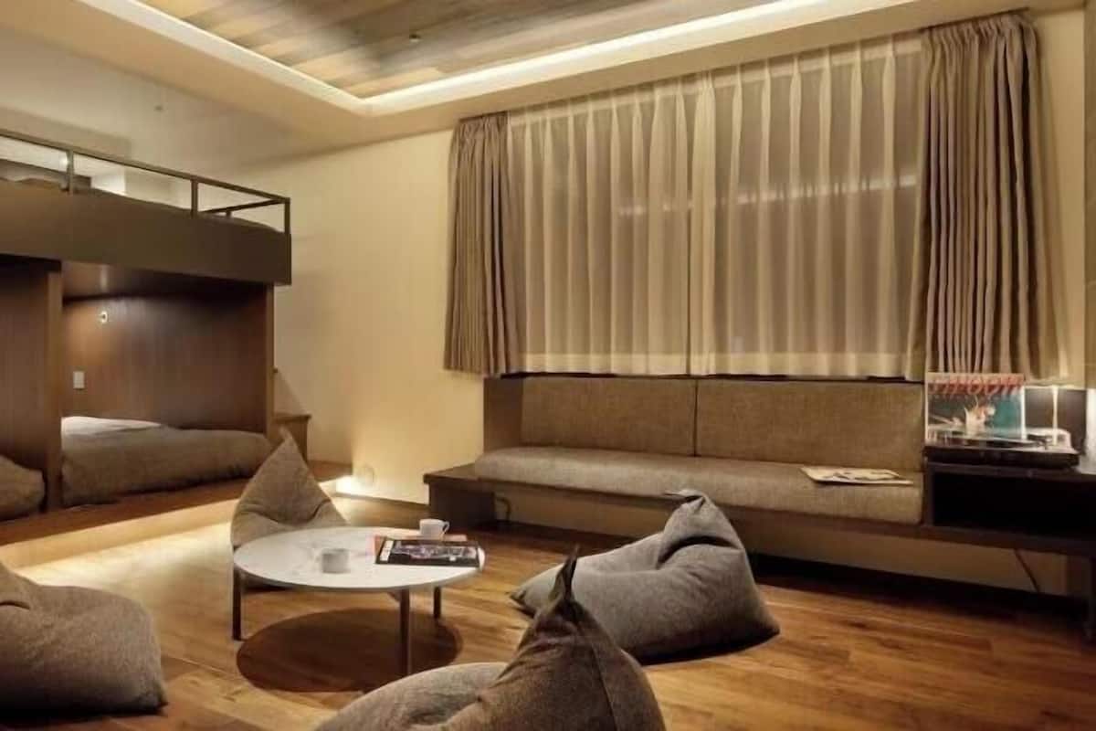 A modern room with bunk beds, a sofa, and bean bags.