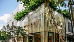 Un bâtiment moderne orn é du logo BVLGARI, avec de grandes fenêtres en verre et une façade élégante.