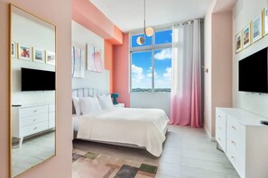 A modern bedroom with a bed, a TV, and a large window with a view.