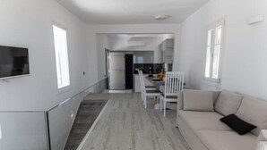 Ein geräumiger Wohnbereich mit Treppe, Essbereich und einer Küche im Hintergrund.