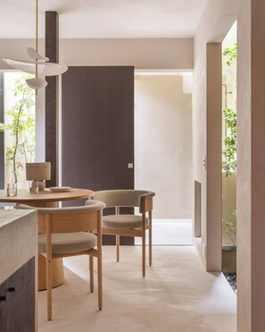 Un intérieur moderne avec une table ronde, deux chaises et un luminaire suspendu.