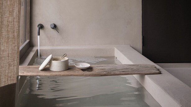 A bathtub with a wooden shelf holding a ceramic container, a bowl, and a brush. - Maana Kiyomizu (Kyoto)
