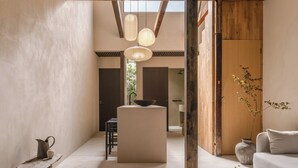 A spacious interior with a high ceiling, wooden beams, a central island, and a sofa. - Maana Kiyomizu (Kyoto)