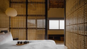 A traditional Japanese-style room with tatami flooring, a low wooden ceiling, and a sliding shoji screen door. - Maana Kiyomizu (Kyoto)