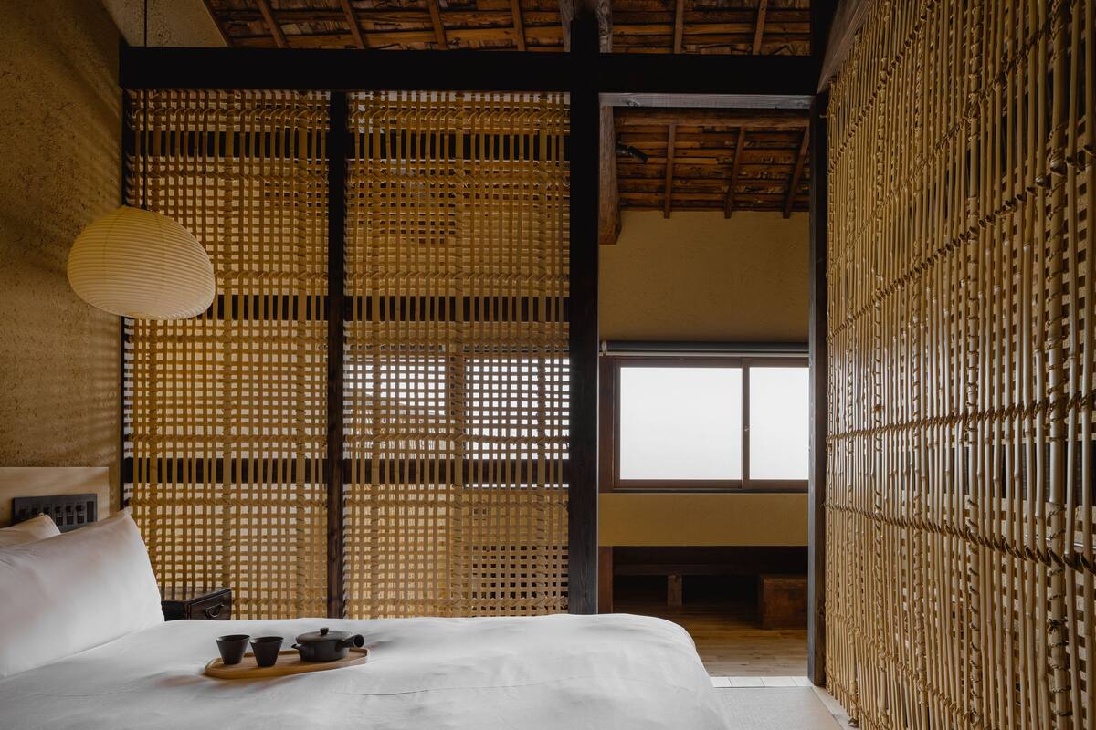 Ein traditioneller japanischer Raum mit Tatami-Bodenbelag, niedriger Holzdecke und einer schiebbaren Shoji-Schiebetür.