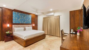 A modern hotel room with a wooden bed, a flat-screen TV, a desk with a chair, and a large window with curtains. - Seasons Boutique Hotel near Sajjangarh Biological Park, Udaipur (Udaipur)
