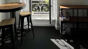 A room with a table and chairs, a bench, a bookshelf, and a view through a glass door to the outdoors. - Exceptional apartment - Seafront (Fouesnant)